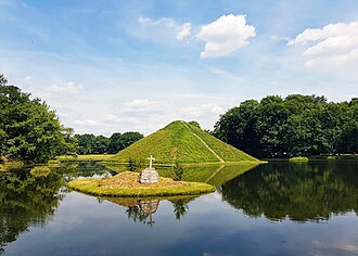 Pyramidensee mit Blick auf die Seepyramide, Begräbnisstätte Fürst Pücklers. Pückler ließ für den Landschaftspark Branitz Seen und Kanäle ausheben und aus dem Aushub Hügel modellieren, sodass aus der flachen Ebene ein Relief entstand. Im Jahr 1856 ließ er hier die Seepyramide, von ihm Tumulus genannt, als seine Grabstätte anlegen. Unweit davon befindet sich Pücklers auf einem künstlichen Hügel errichtete Landpyramide.