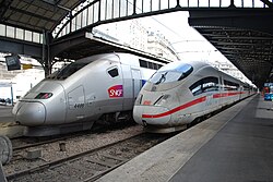 Zwei Züge stehen nebeneinander in einem Bahnhof