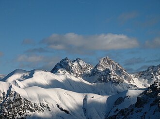 Krottenspitze, Öfnerspitze und Großer Krottenkopf; deutlich kontrastieren die weichen schneebedeckten aus Allgäuschichten bestehenden Almen (Grasberge) gegen den schroffen Hauptdolomit, aus denen die genannten Gipfel sowie die Partien rechts unten und links unten bestehen.